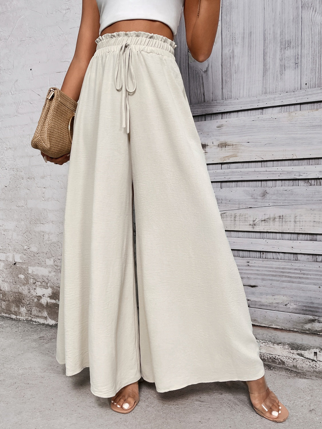 High waisted Wide leg pants featuring ruffled elasticated waistline with drawstring tie. 