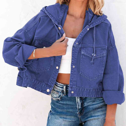 A stylish royal blue hooded denim jacket with a button up front, flap pockets and adjustable drawstring hood. The Jacket features a relaxed fit with rolled-up sleeves, paired with a white crop top and blue jeans for a casual trendy look.